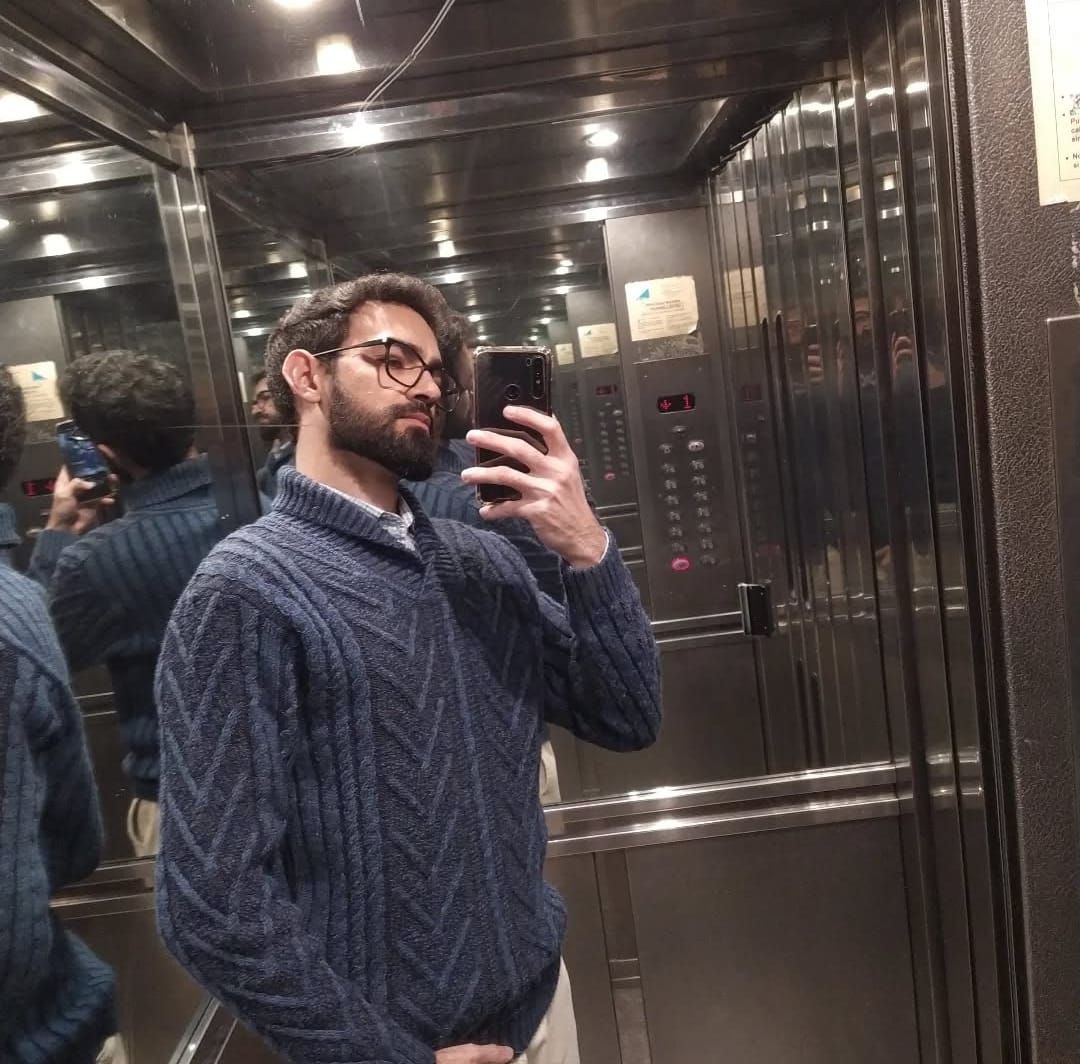 Sodre, barbero, con anteojos y suéter azul